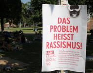 Foto von Plakat im Stühlinger Park mit der Aufschrift "Das Problem heißt Rassismus"