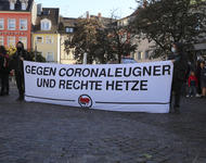 Weißes Transparent, auf dem in schwarzer Schrift steht: "Gegen Coronaleugner und rechte Hetze". Außerdem Antifa-Symbol.
